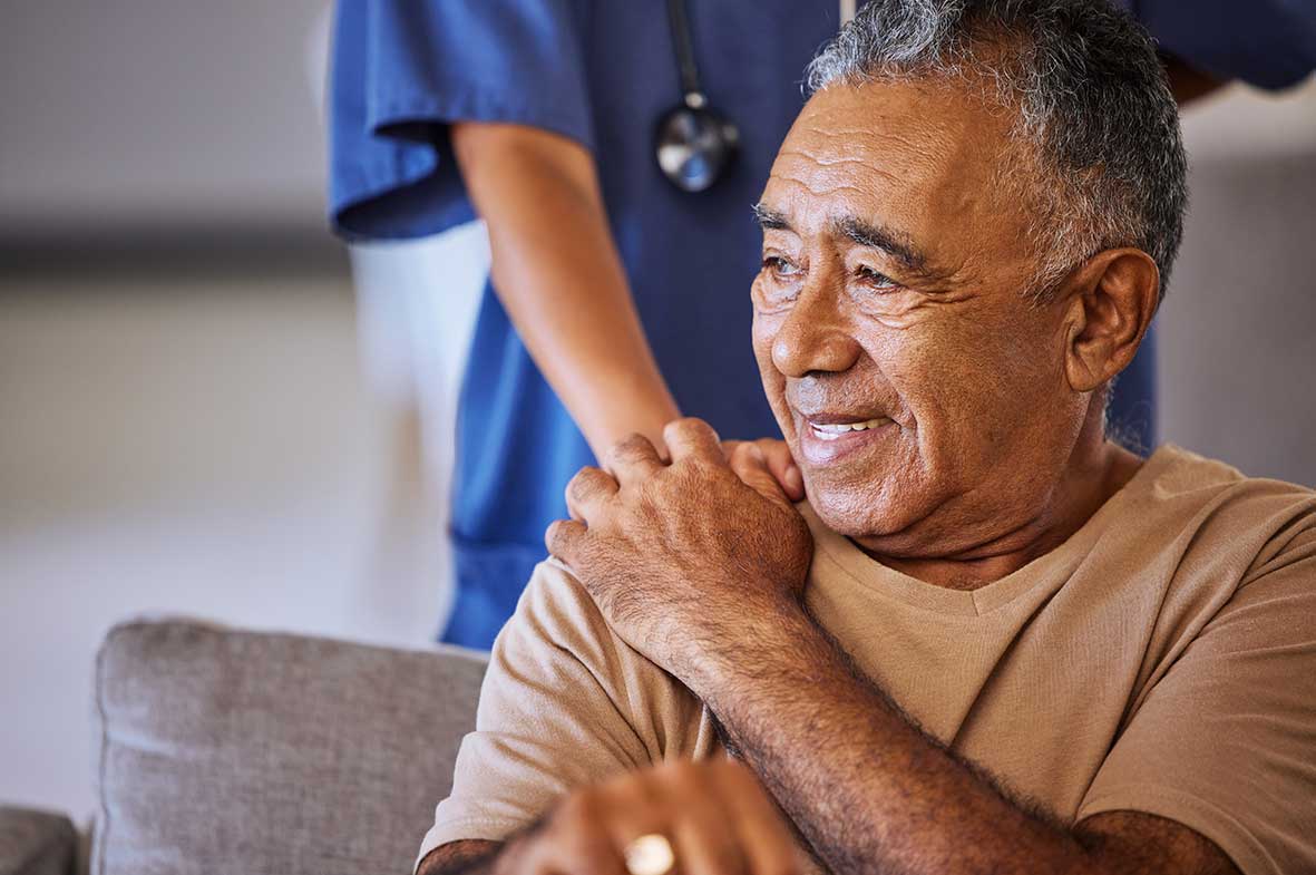 Caregiver holding hand of a senior patient and showing kindness while doing a checkup